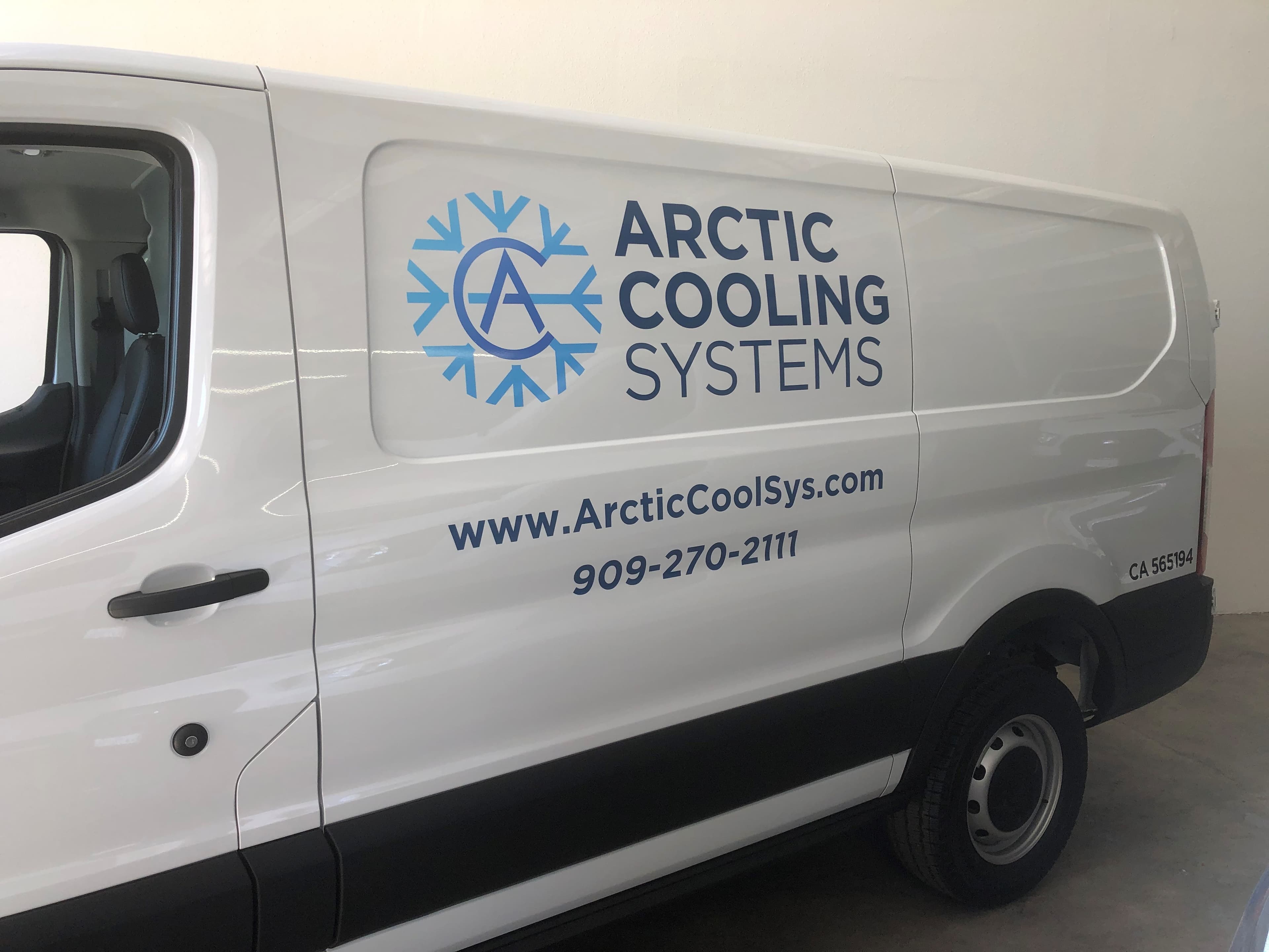 White service van with a die-cut Arctic Cooling Systems snowflake logo, web address, phone number and contractor licence number